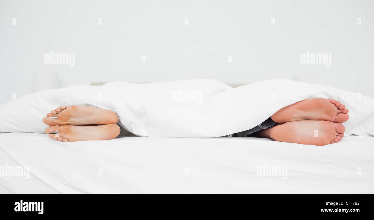 Mann und Frau die Füße in einem Bett von einander abgewandt Stockfoto