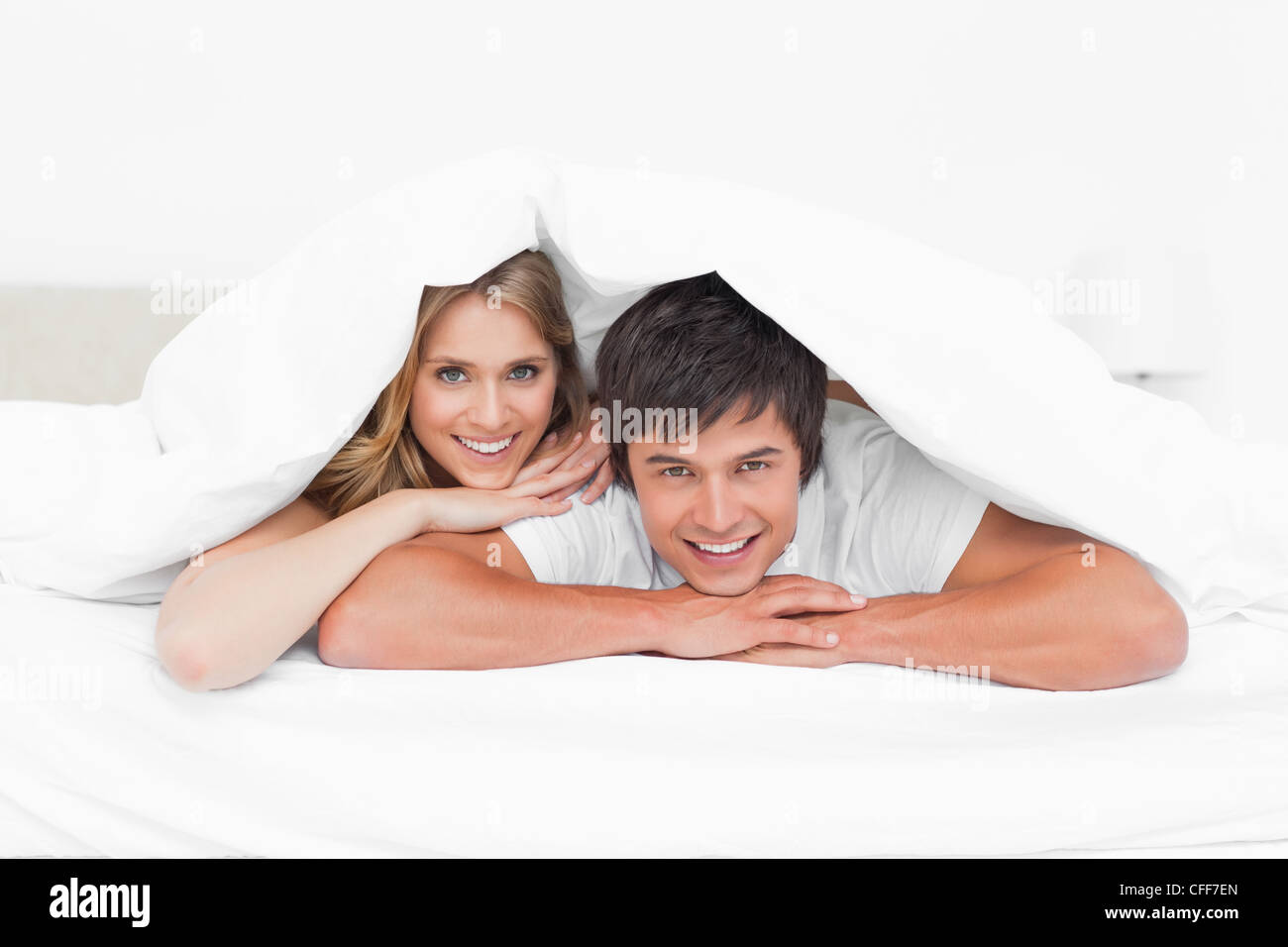 Mann und Frau am Rand des Bettes, lächelnd und ich freue mich aus dem quilt Stockfoto