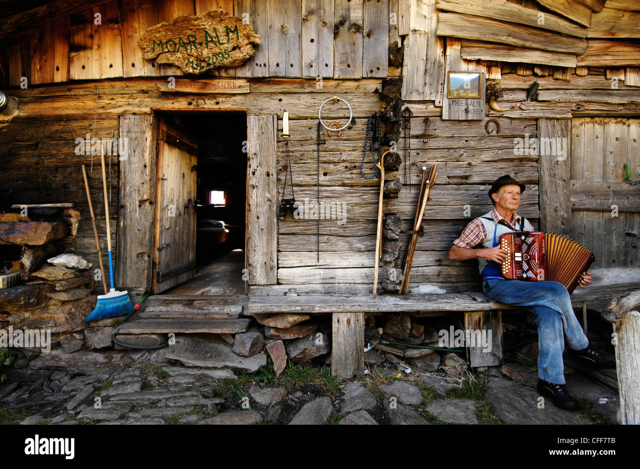 Käser spielt Akkordeon vor seinem Haus Schnals Tal, Alto Adige, Südtirol, Italien Stockfoto