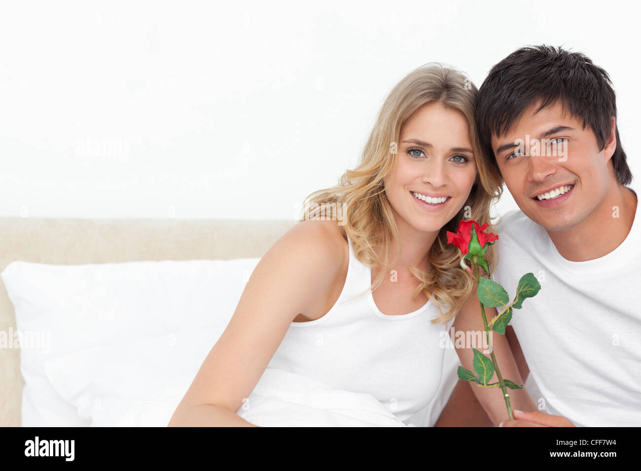 Frau und Mann lächelnd geradeaus mit einer Rose in der hand Stockfoto