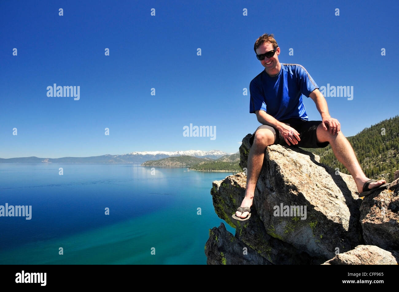 Ein Mann entspannt auf einem Felsen mit Blick auf Lake Tahoe im Sommer, Nevada. Stockfoto