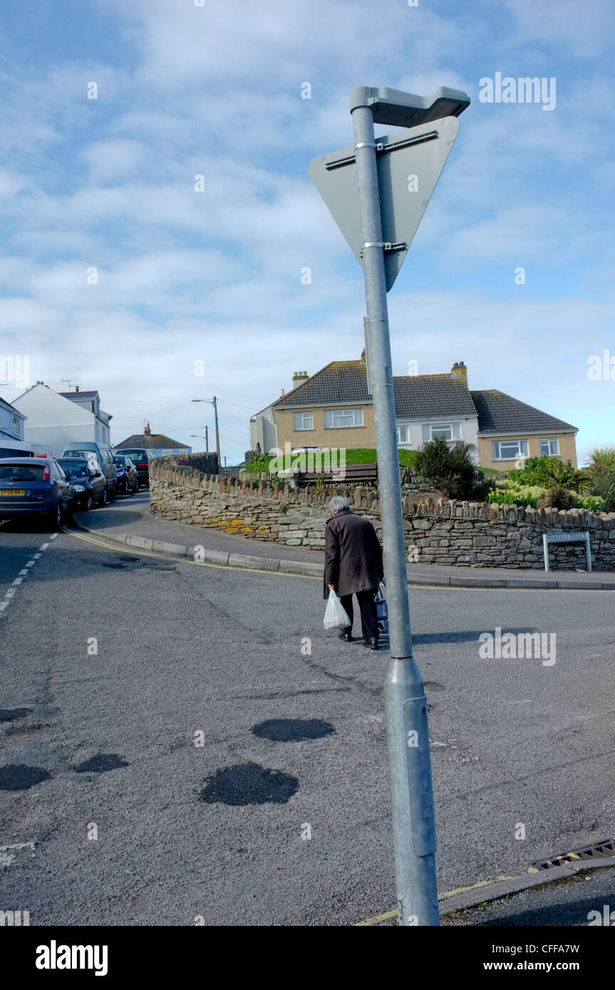 Ein Alter Mann geht auf einem steilen Hügel in Falmouth, England Stockfoto