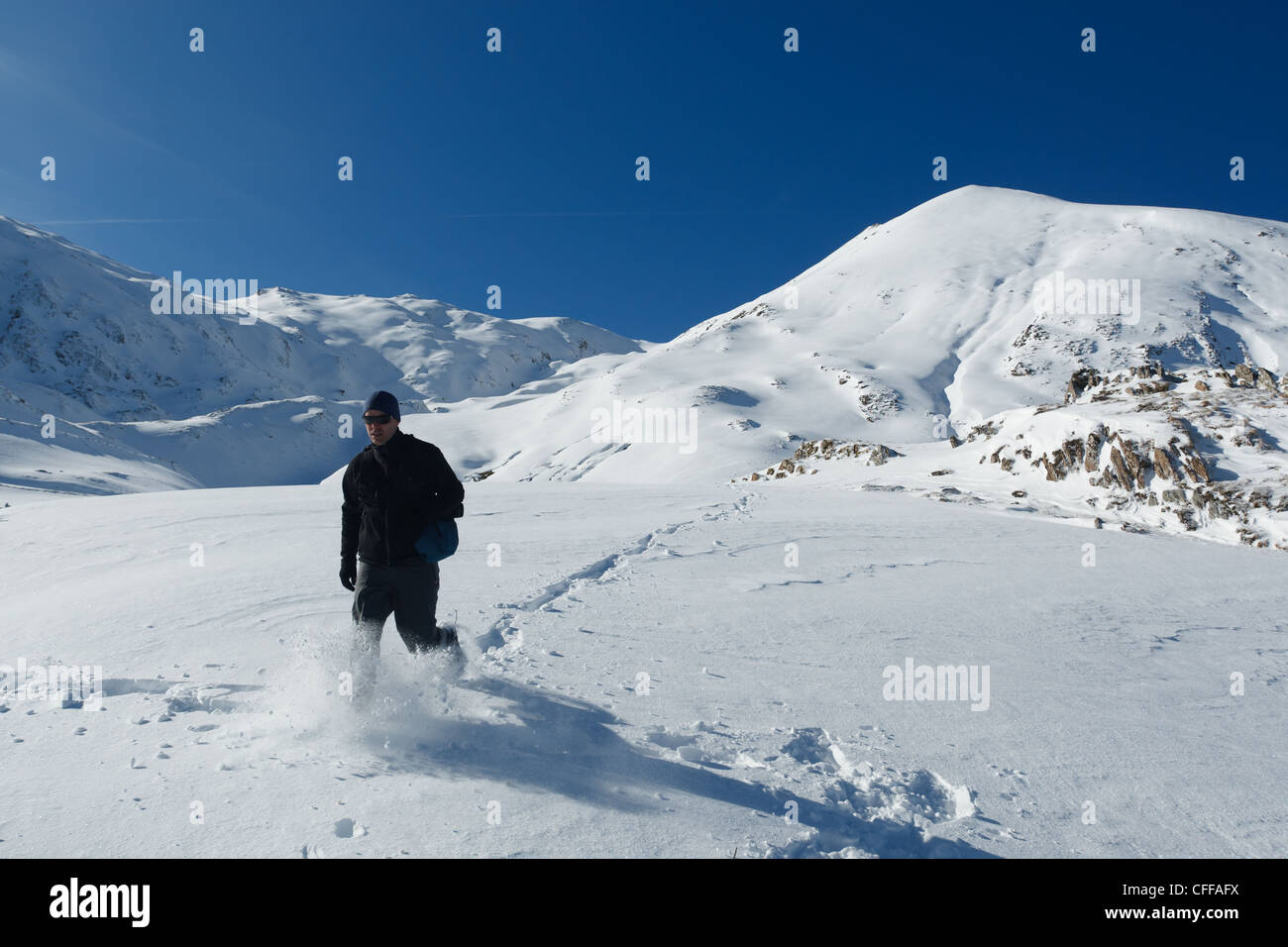 Mann zu Fuß durch dicke Pulver in verschneite Berglandschaft in der Nähe von Col de Pause, Ariege, Pyrenäen, Frankreich. Stockfoto