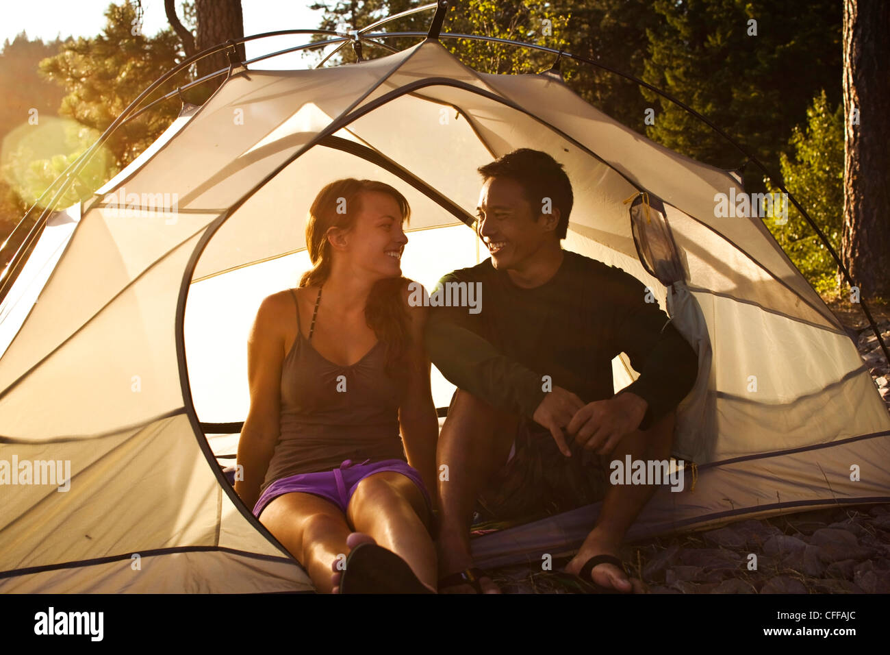 Eine glückliche junge Erwachsene paar Lächeln und Lachen auf einem camping-Ausflug an einem See in Idaho. Stockfoto