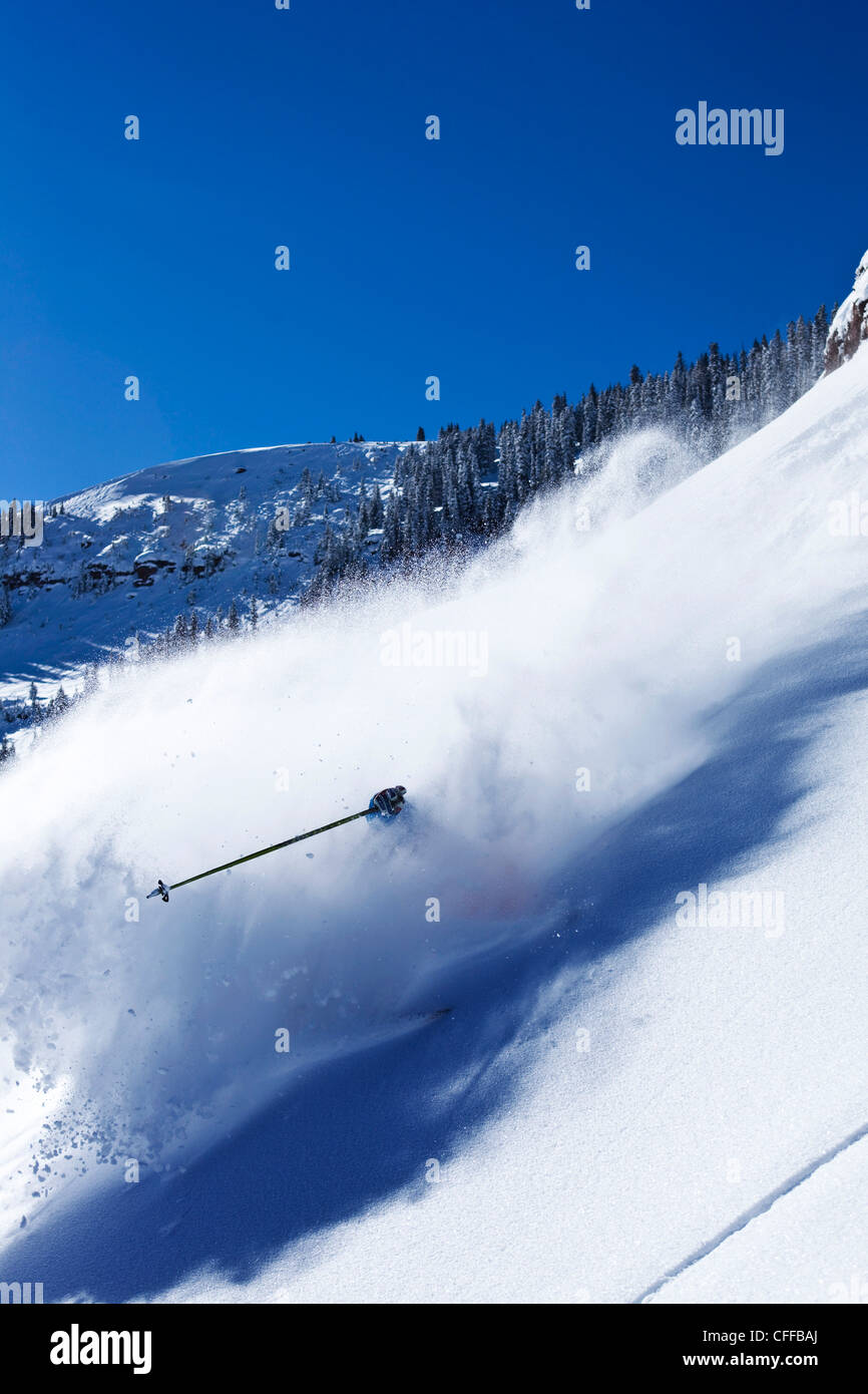 Ein sportliche Skifahrer reißt frischen Tiefschnee Umdrehungen im Hinterland an einem sonnigen Tag in Colorado. Stockfoto