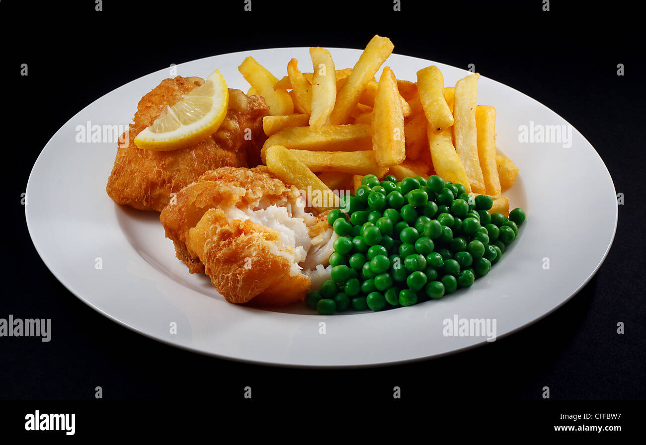 Nahaufnahme von Fish And Chips mit Erbsen und einer Scheibe Zitrone. Ein traditionelles Gericht der britischen Küste Stockfoto