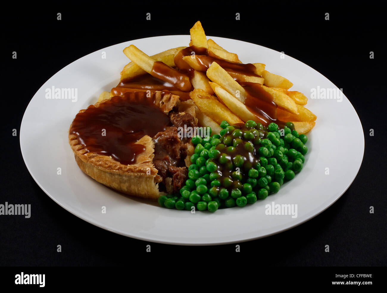 Nahaufnahme von Steak Pie und Chips mit Erbsen und Soße. Ein traditionelles britisches Gericht Stockfoto