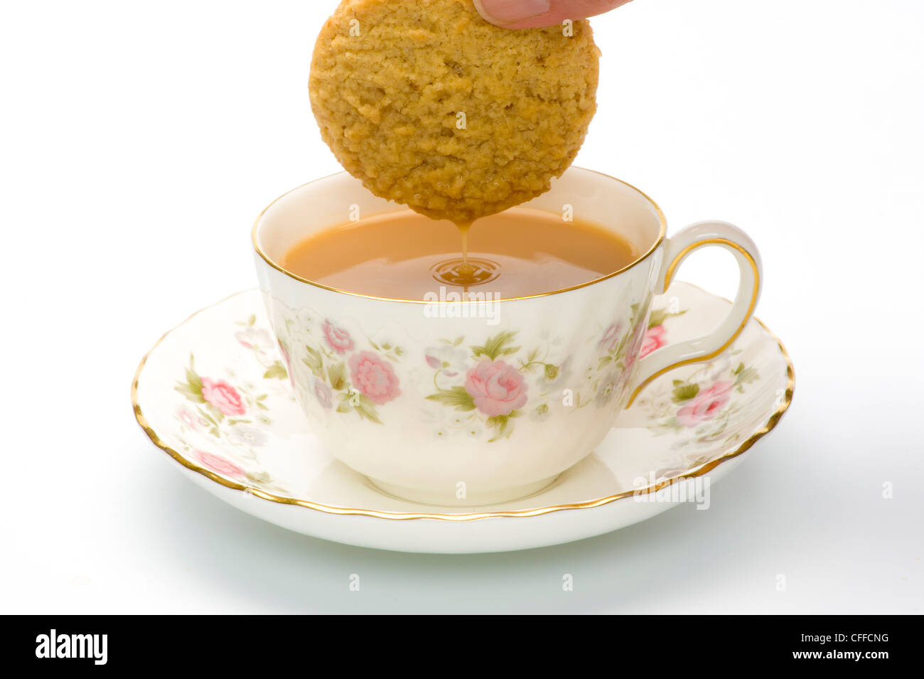 Biscuit tropft mit Flüssigkeit, wurde in eine tasse mit Tee eingetaucht. Stockfoto