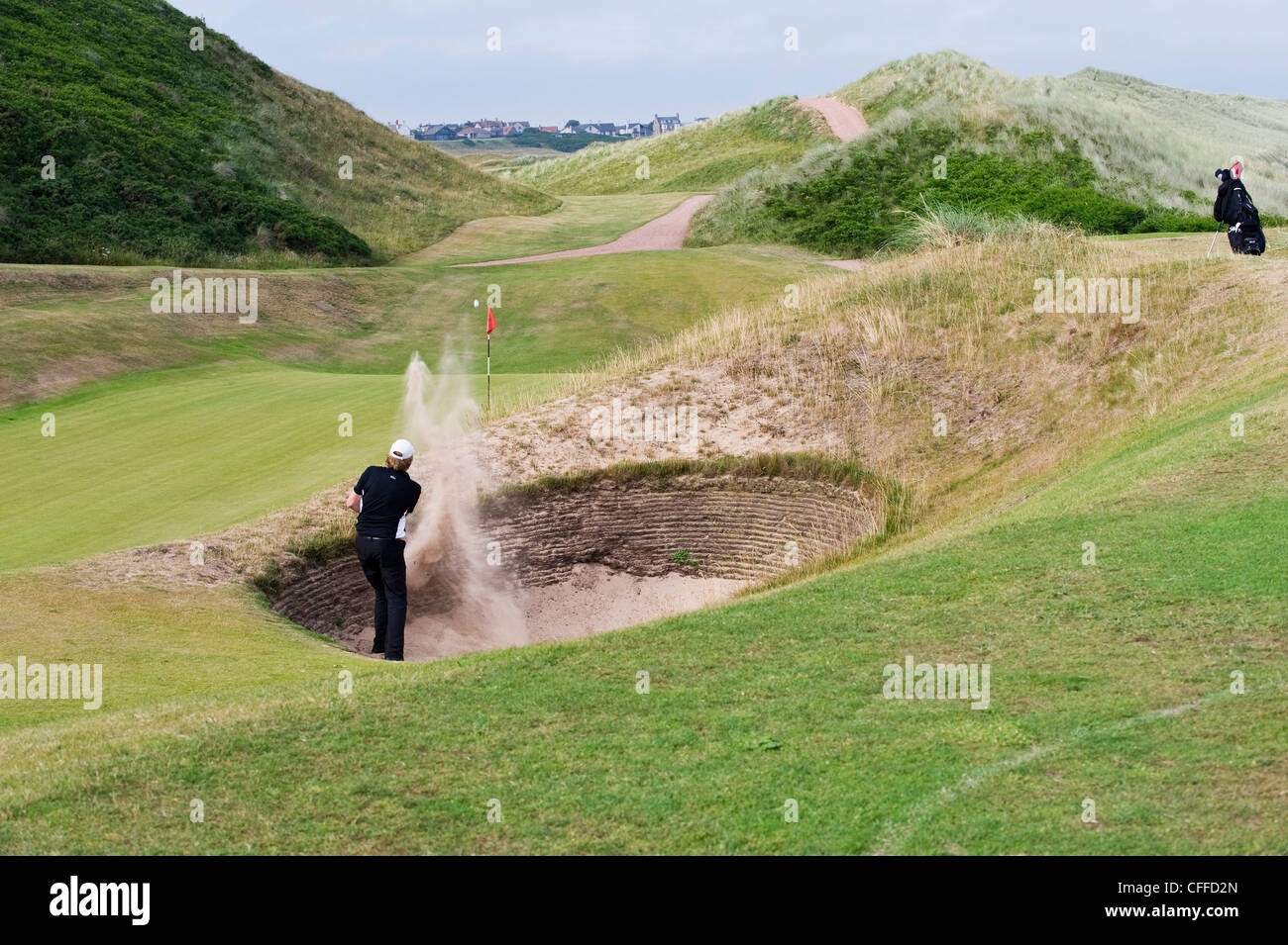 Ein Golfspieler einen Schuss aus einem Bunker zu schlagen Stockfoto