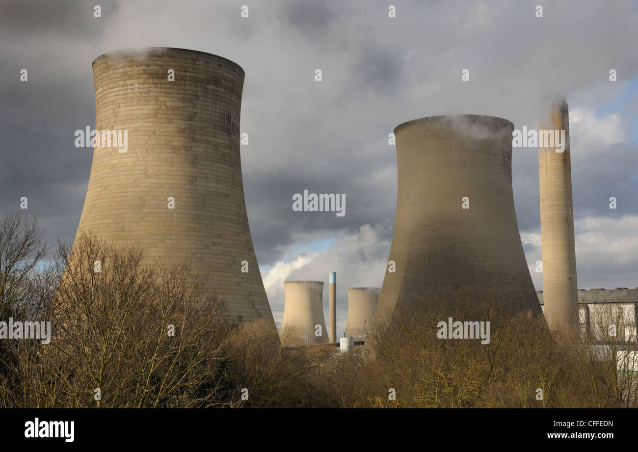 Riesige Kühltürme in einem Kraftwerk Strom. Weißer Dampf gegen ein stimmungsvoller Himmel mit Wintersonne. Stockfoto