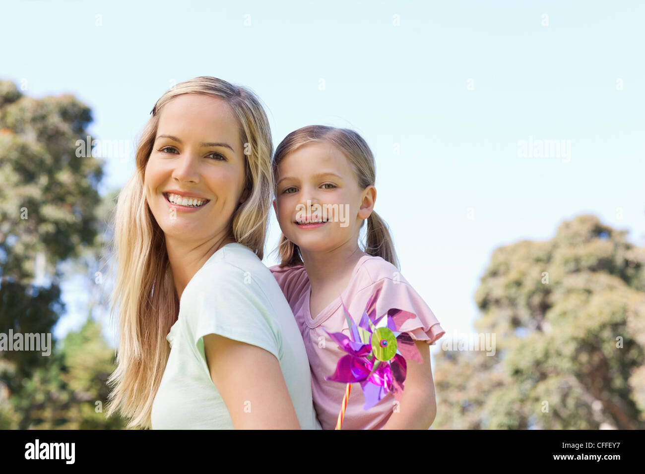 Tochter stehen hinter ihrer Mutter mit einem Pin-Rad Stockfoto