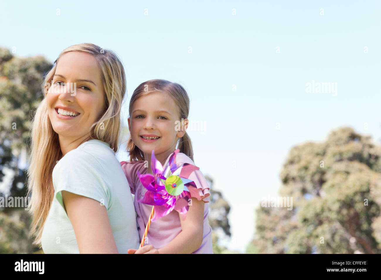 Eine lächelnde Mutter und Tochter mit einem Pin-Rad in der hand Stockfoto
