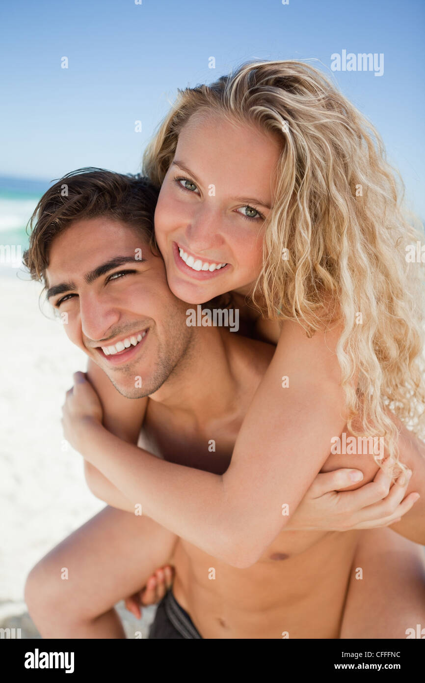 Schönen jungen Mann mit ihrer Freundin ein Piggy-back Stockfoto