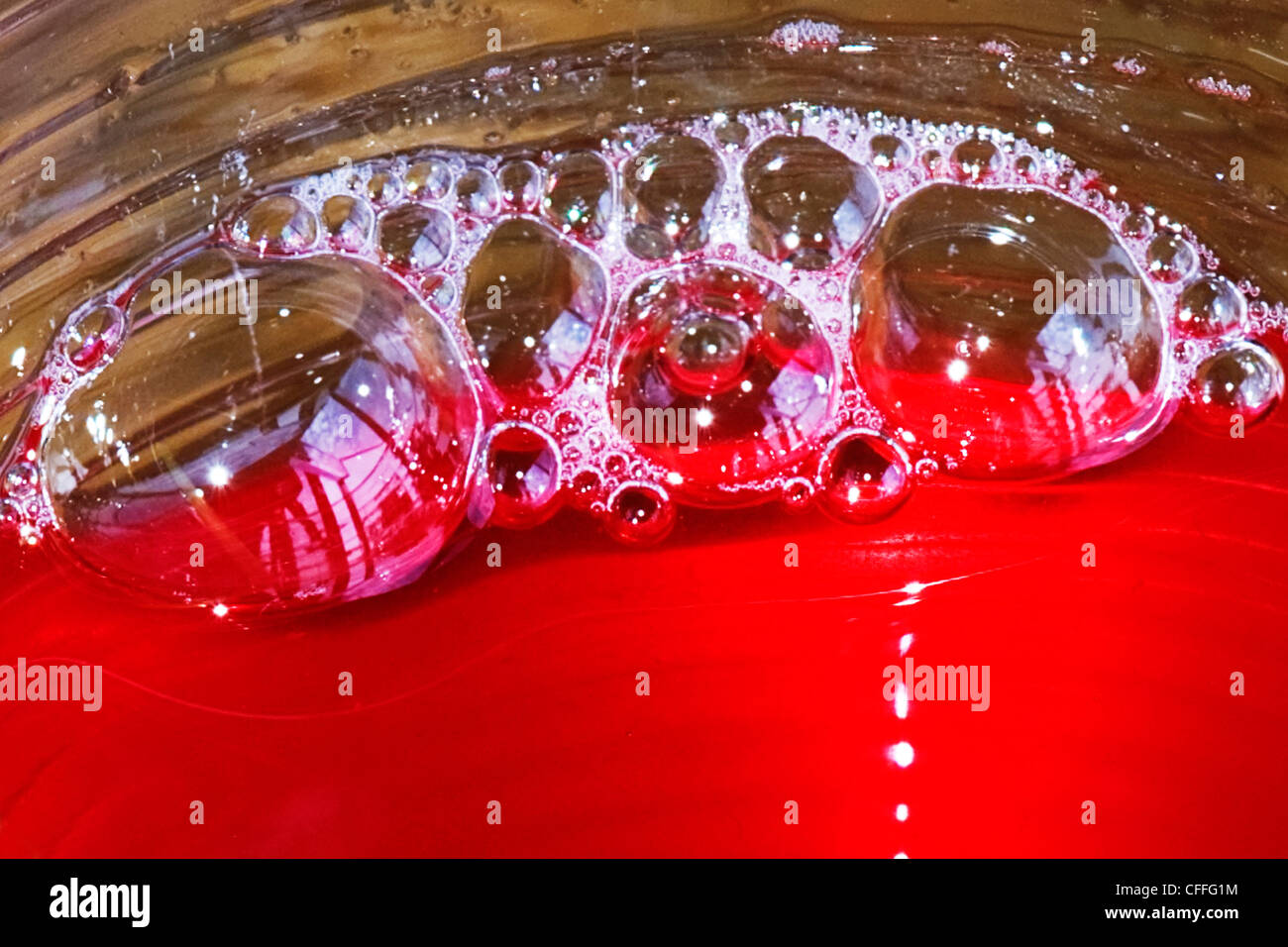 Mikro Makro Nahaufnahme Foto Fotografie abstrakte Muster Farbe Farbe transparent durchscheinende rote Flüssigkeit Blase Luftblasen Schaum Stockfoto