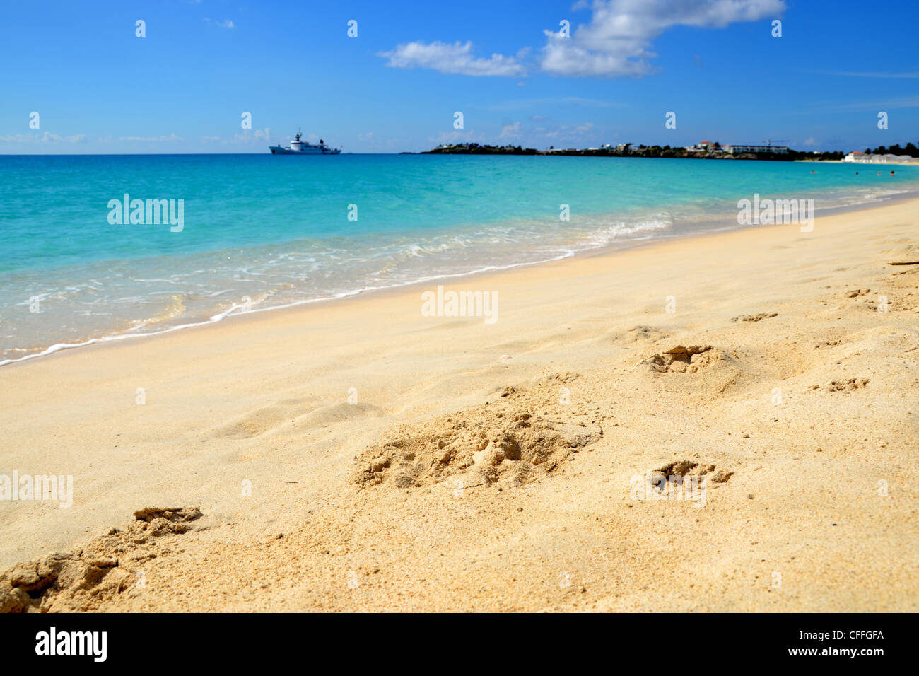 Landschaftsfoto der Küste am Strand mit Fußabdrücken im Sand, türkisfarbenem Wasser und Horizont. Stockfoto