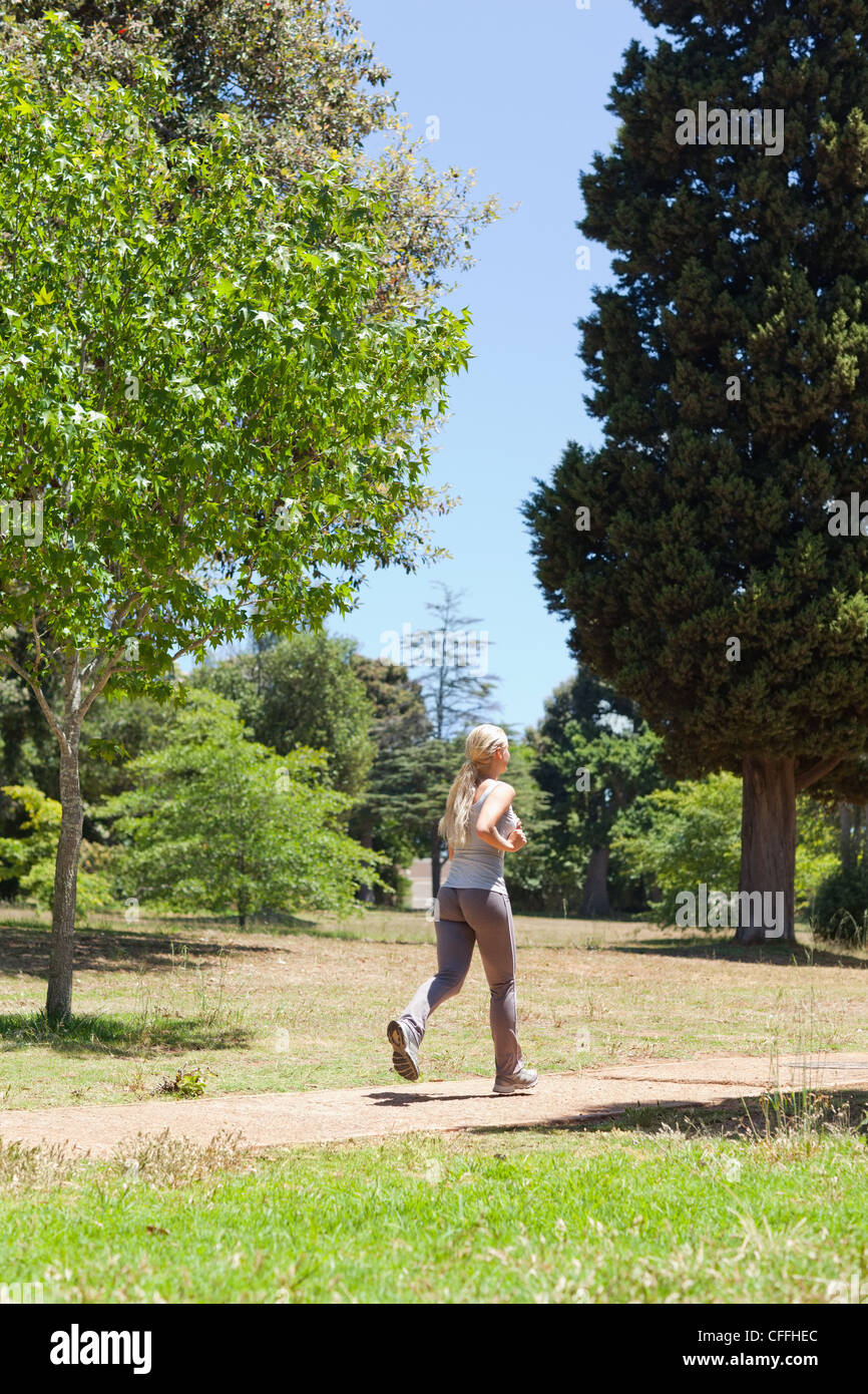 Sportlerin, die durch den Park Joggen Stockfoto