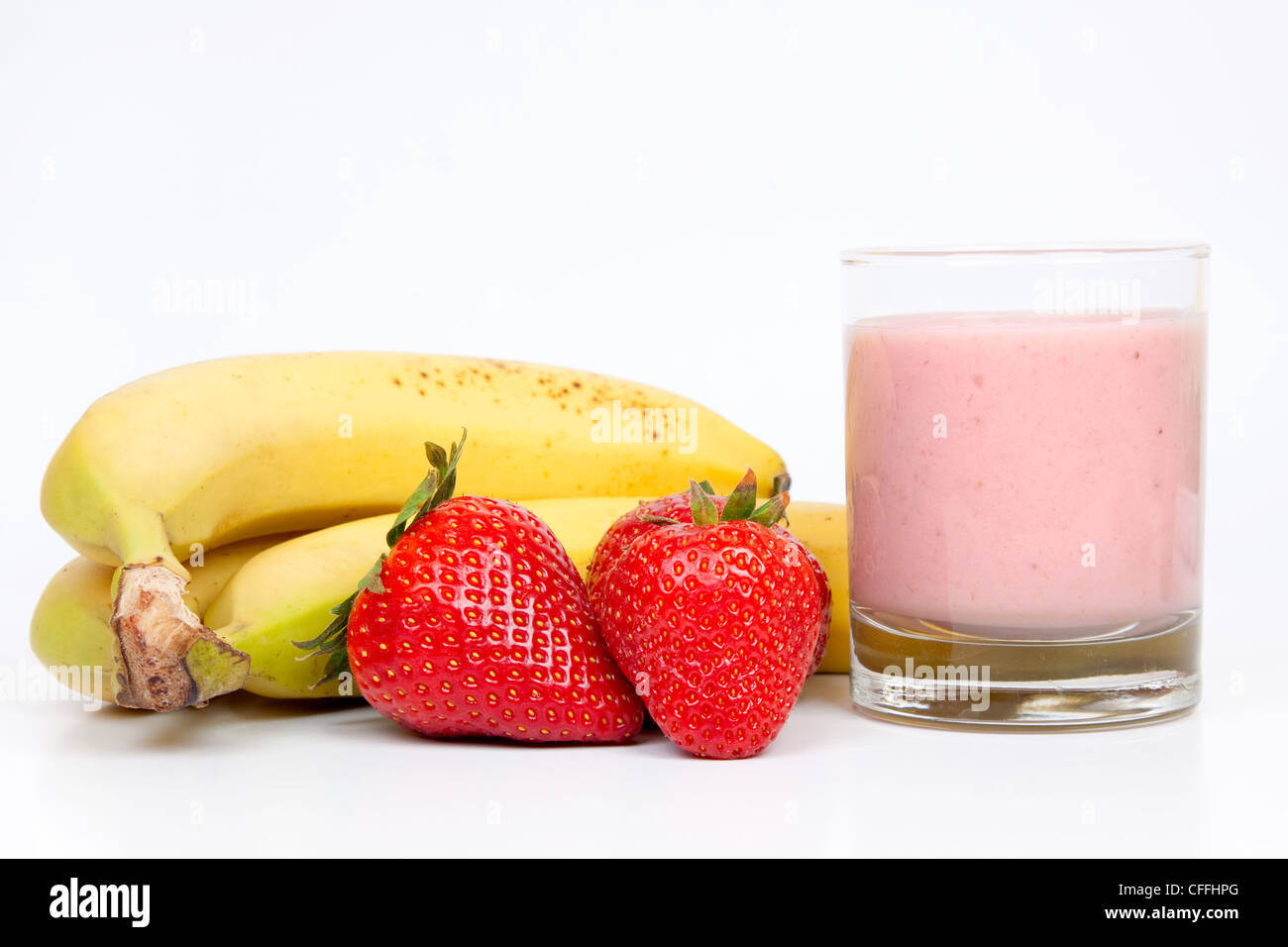 Gruppe von Bananen und Erdbeeren mit einem Kopfschütteln Erdbeeren und Milch auf einem weißen Hintergrund. Stockfoto
