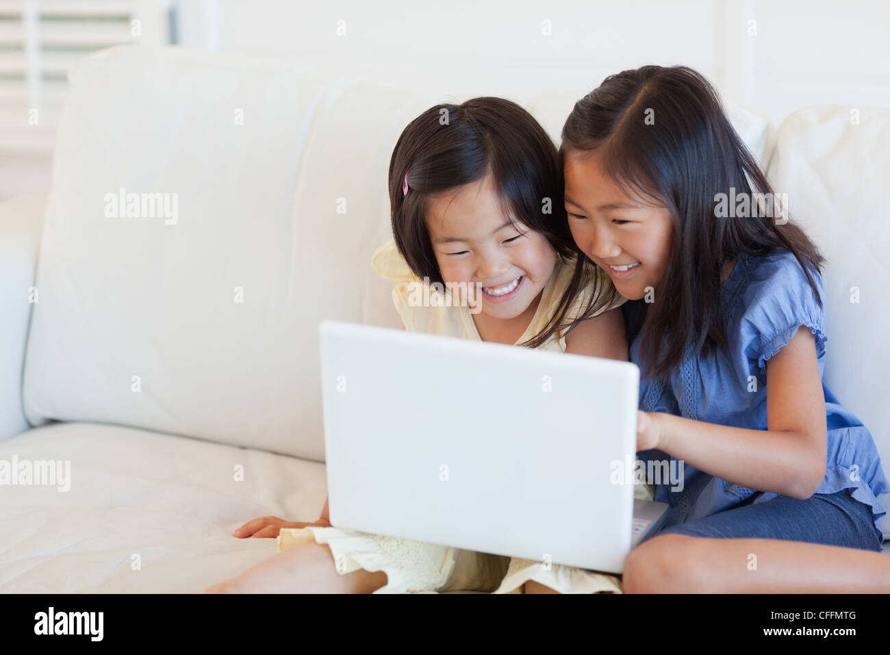 Zwei unterhalten Mädchen auf den Bildschirm des Laptops, wie sie sitzen Stockfoto