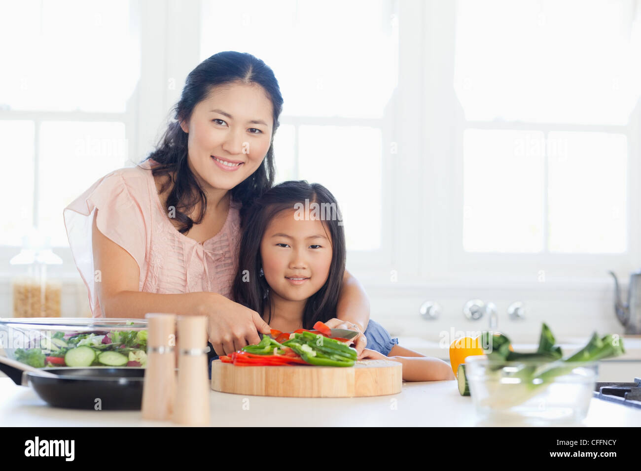 Eine Mutter und ihr Kind schneiden Paprika in der Küche Stockfoto