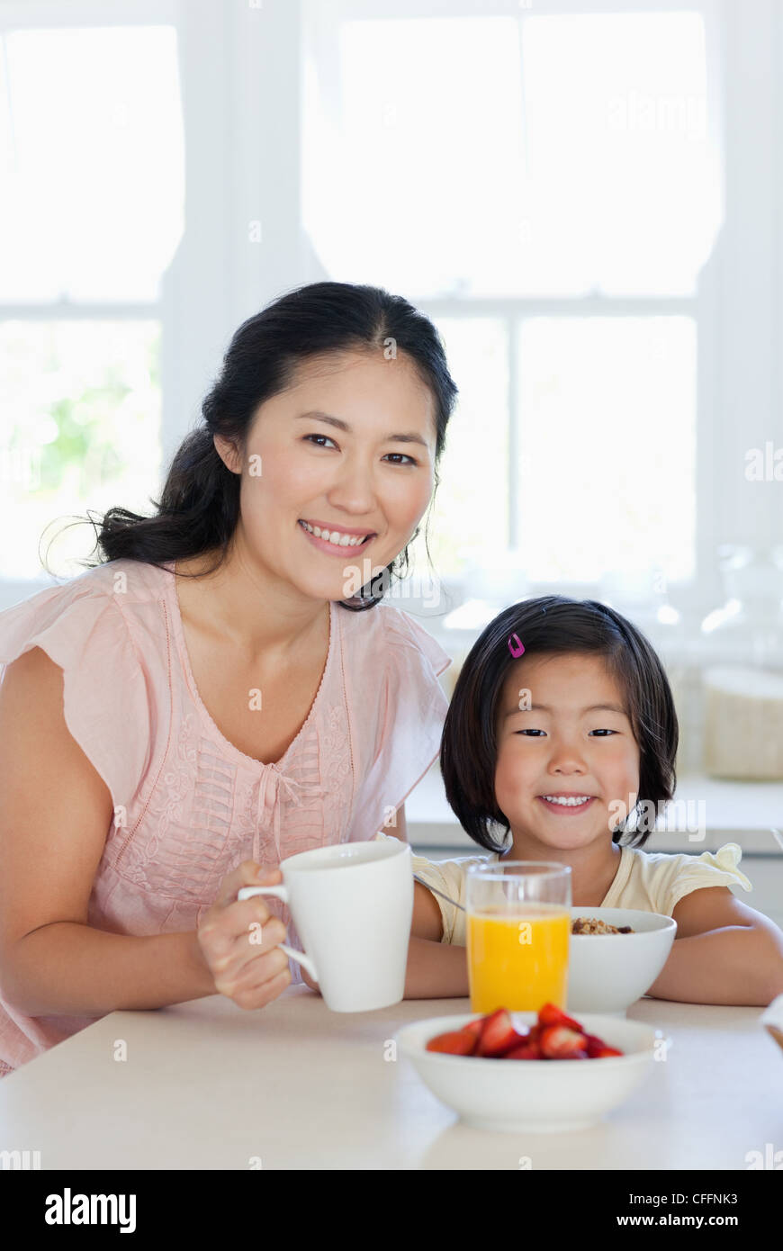 Eine Mutter und Tochter sitzen am Tisch um etwas zu essen zu genießen Stockfoto