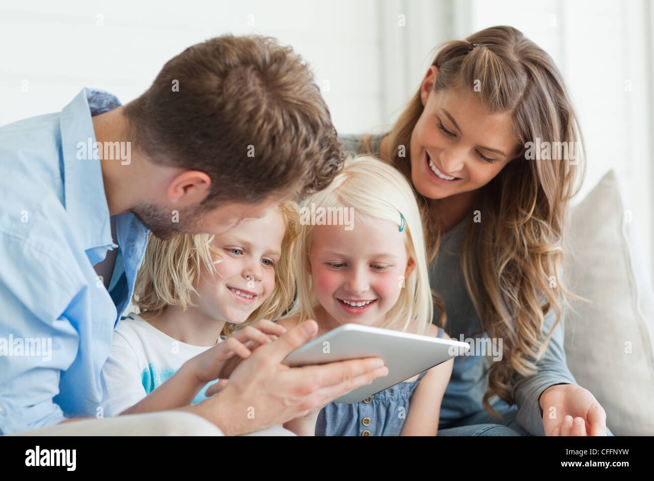 Die Kinder lachen, als sie den TabletPC in der Hand von Papa sehen Stockfoto