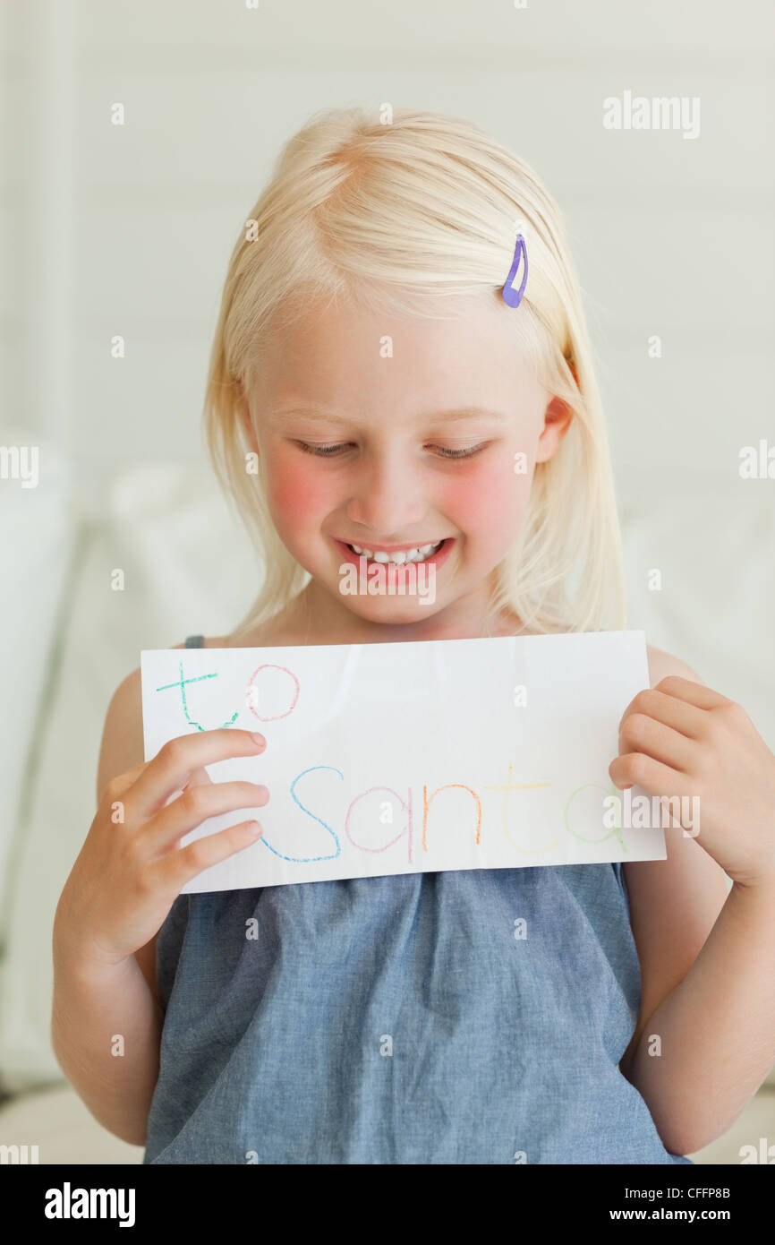 Ein lächelndes Mädchen mit einem Brief an den Weihnachtsmann zu gehen Stockfoto
