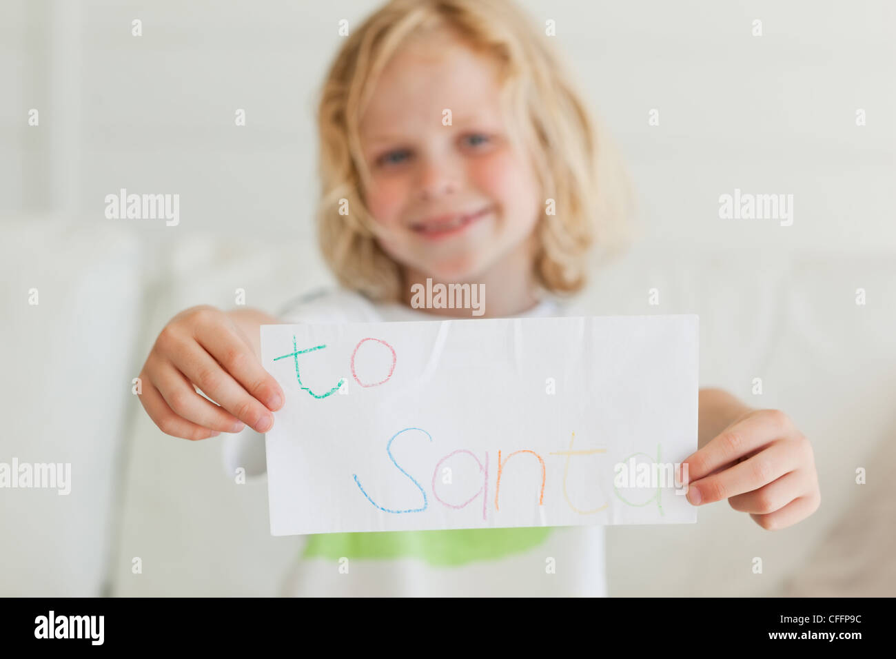 Ein kleiner Junge hält einen Brief an den Weihnachtsmann Stockfoto