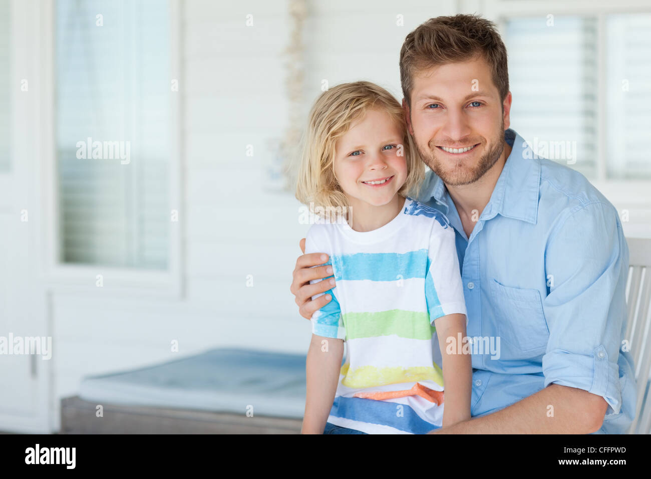 Vater und Sohn, die außerhalb des Hauses zu Lächeln, als sie zusammen sitzen Stockfoto