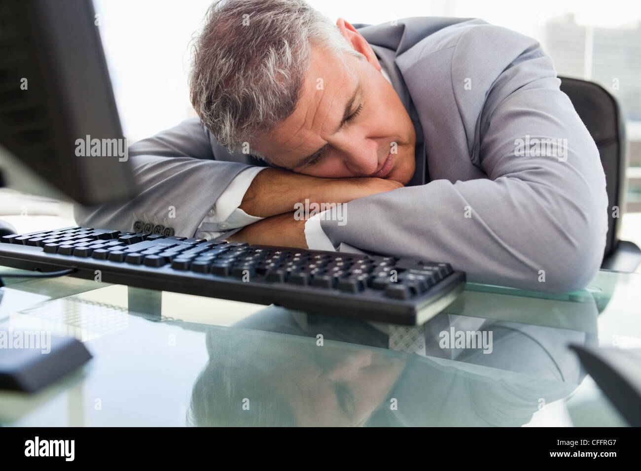 Unternehmer, die auf seinem Schreibtisch schlafen Stockfoto