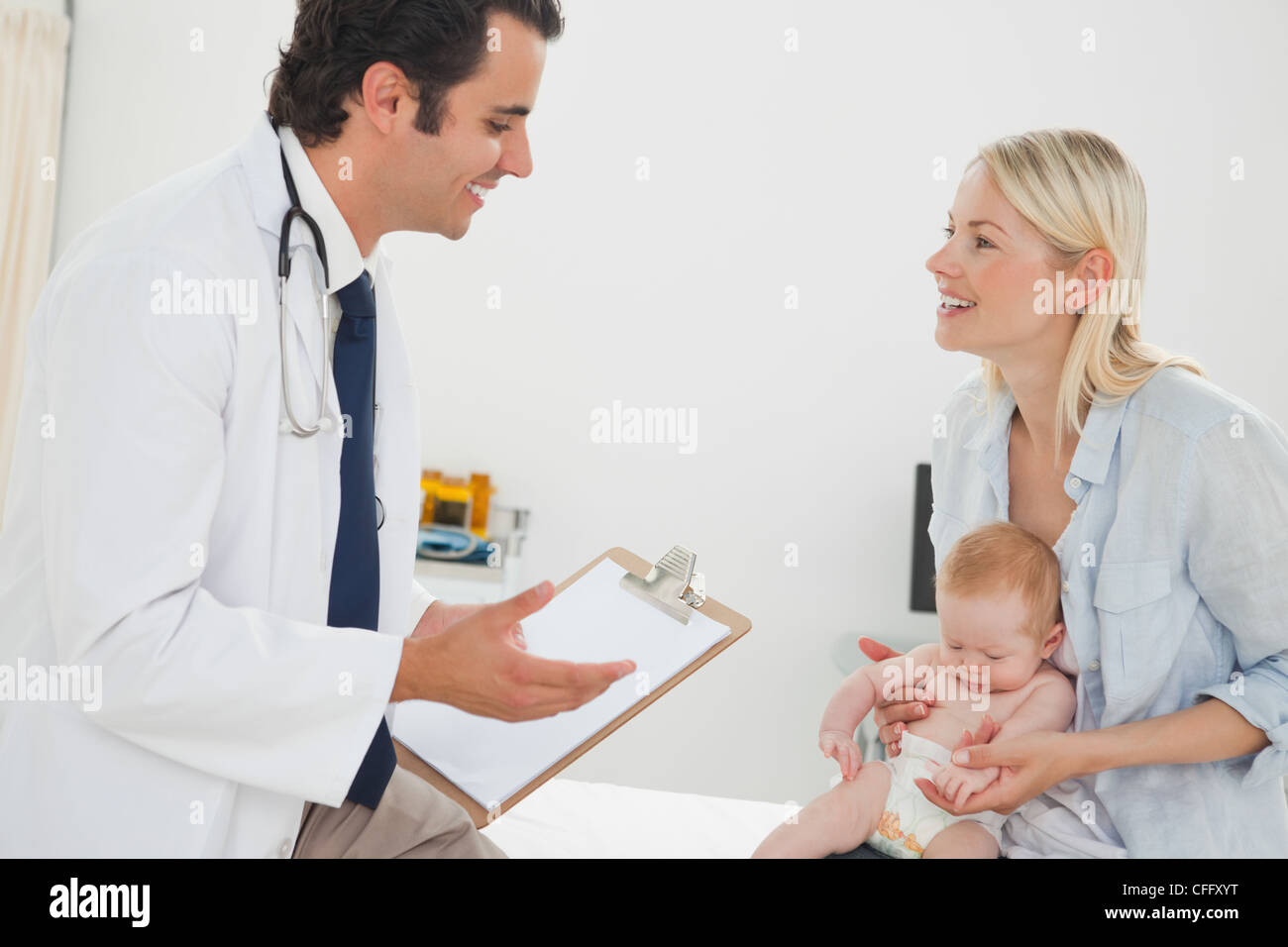 Arzt im Gespräch mit Mutter über ihr baby Stockfoto