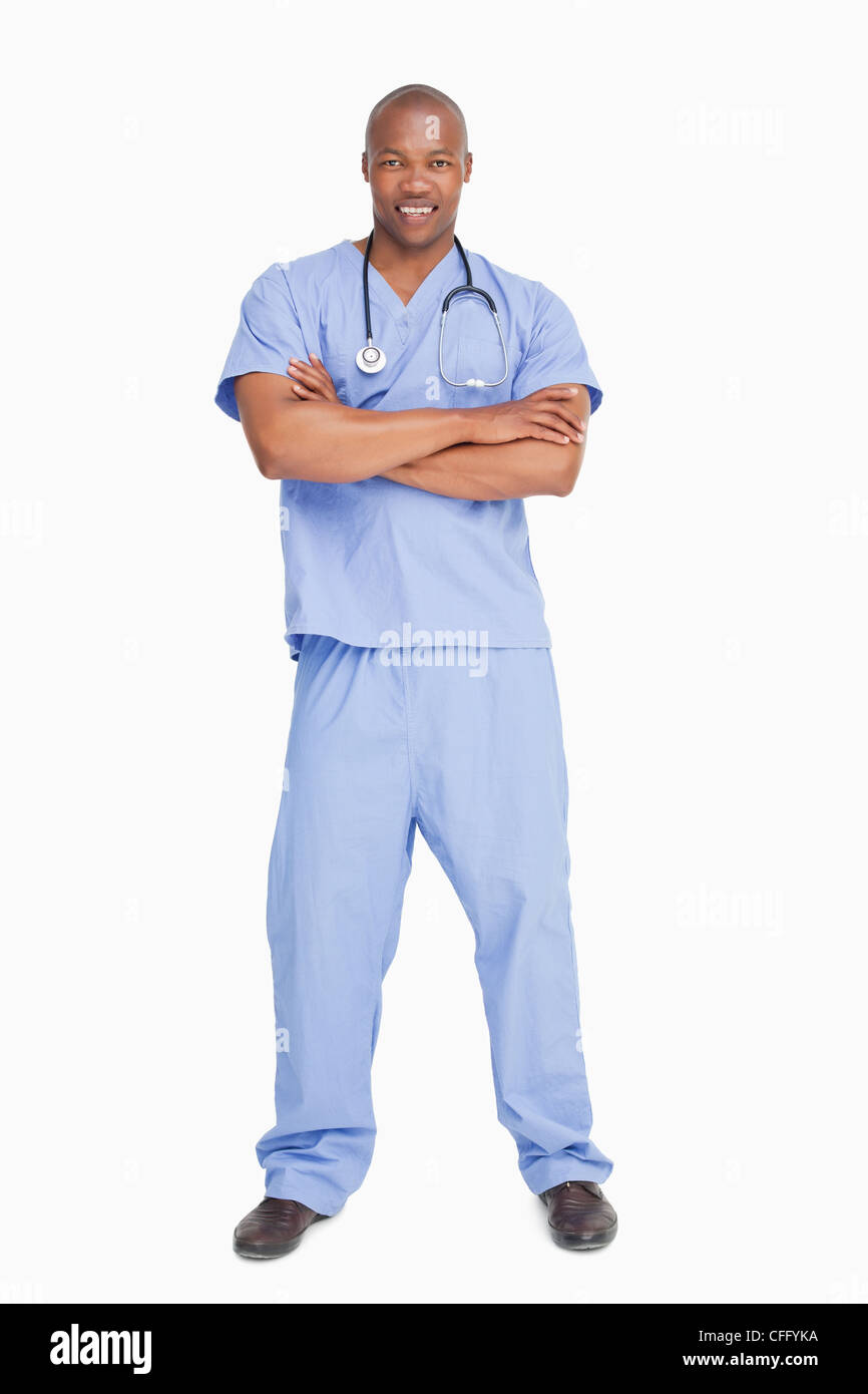 Lächelnd Arzt in Scrubs mit seinen Armen gefaltet Stockfoto