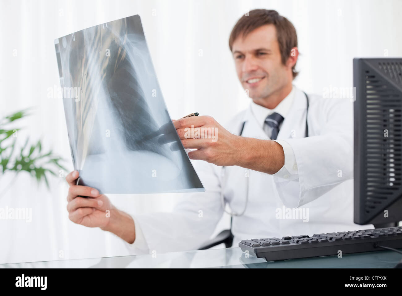 Ein Röntgenbild der Brust gehalten von einem lächelnden Arzt Stockfoto