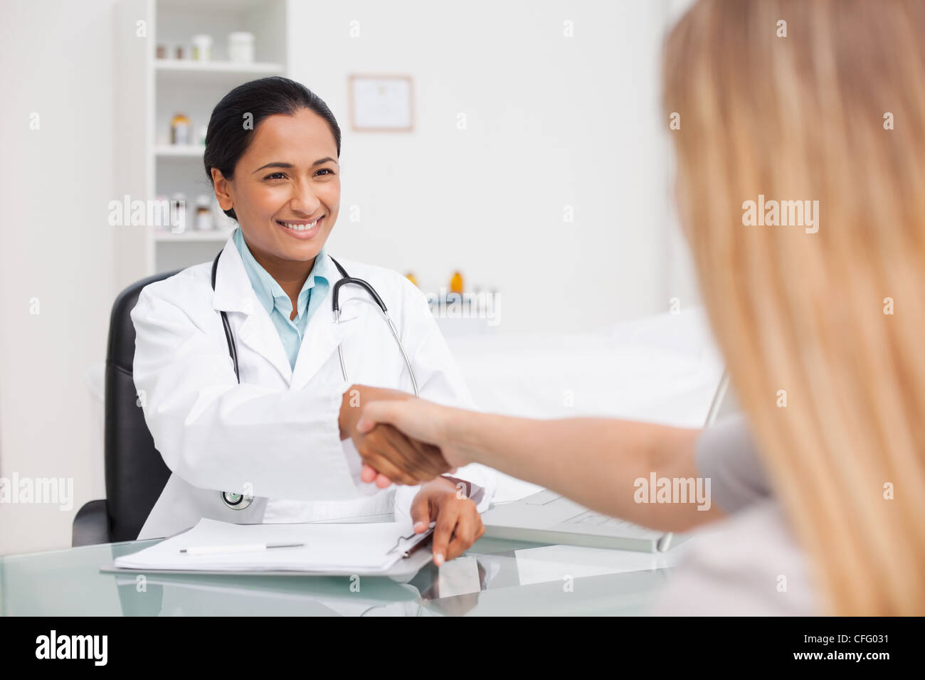 Lächelnd, Arzt und ihrer Patientin, die Hände schütteln Stockfoto