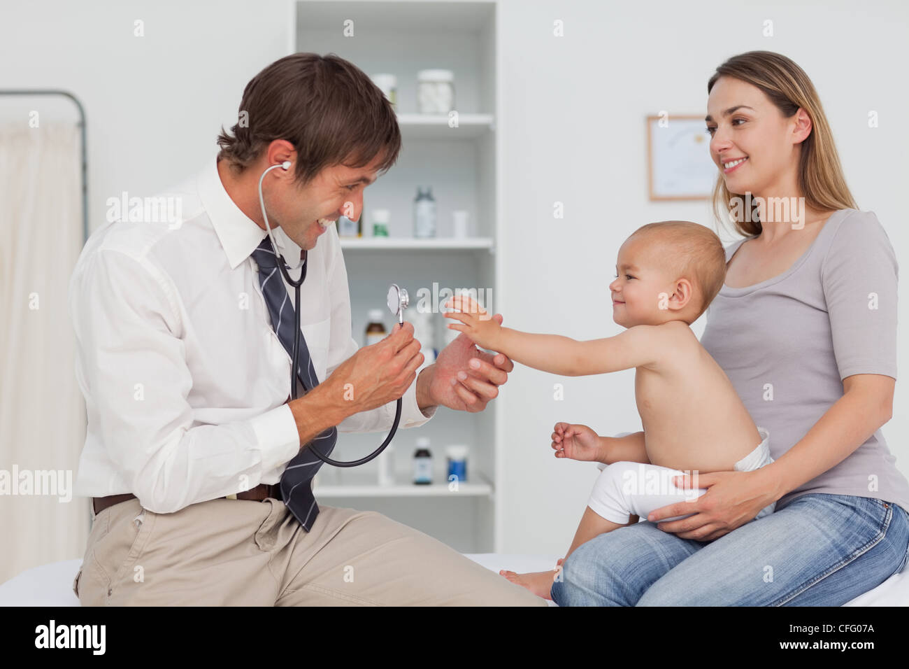 Kleines Baby ihre Hand zu reichen, während durch den Arzt geprüft wird Stockfoto