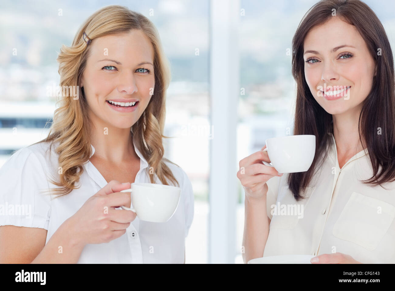 Zwei Freunde Lächeln, als sie nach vorne schauen und Tee trinken Stockfoto