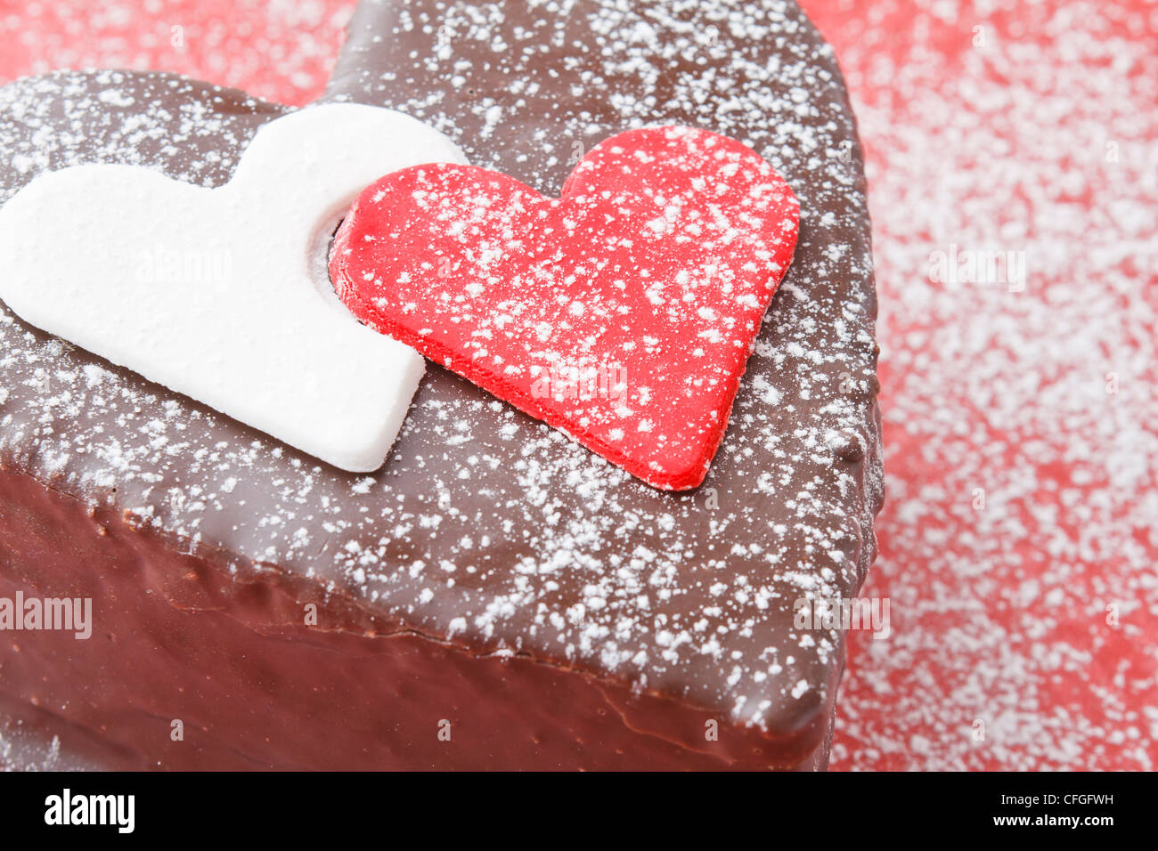 Ein Schokolade-Kuchen auf rotem Grund in Herzform Stockfoto