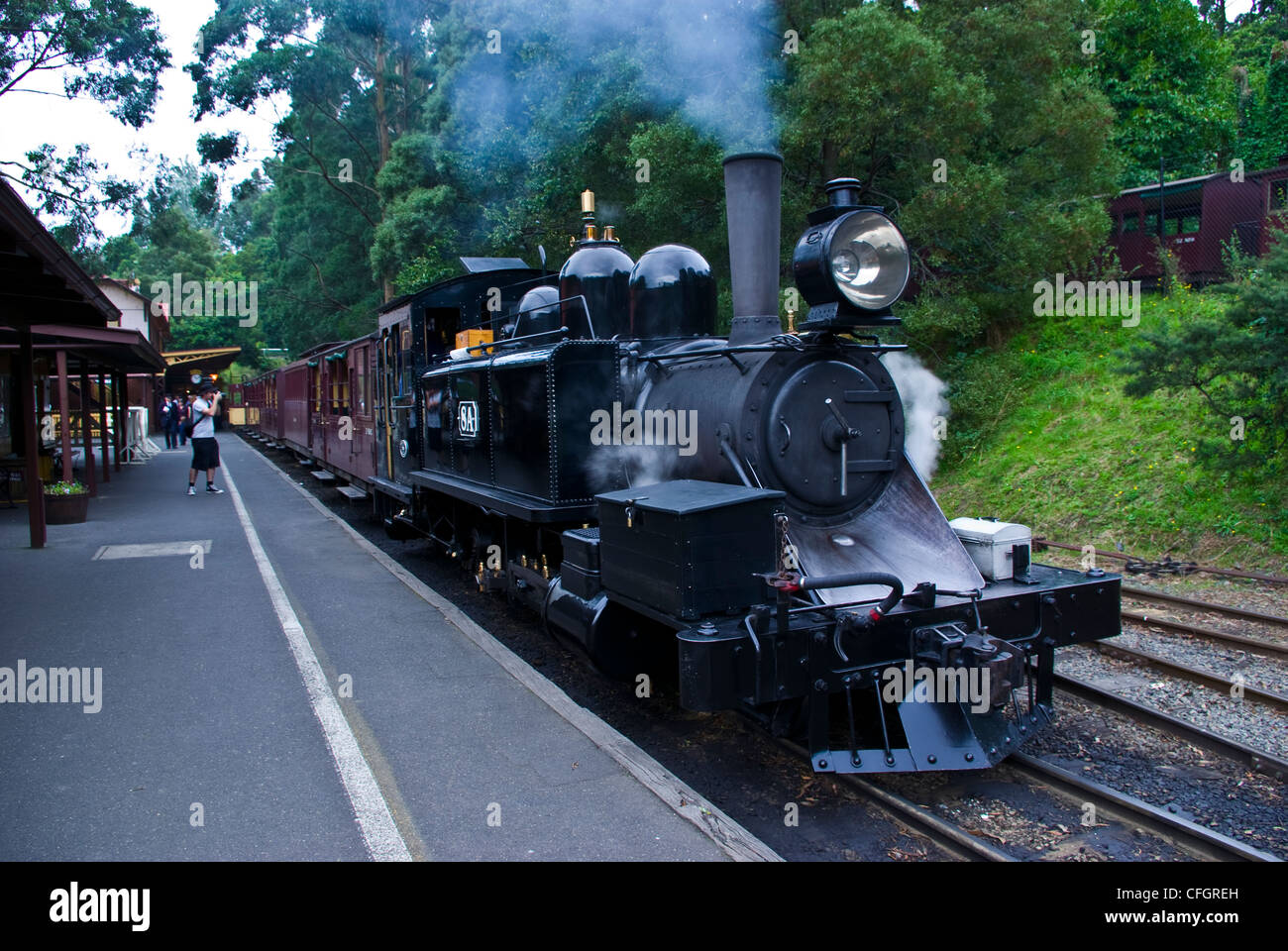 Ein Erbe Dampfzug bläst Rauch aus seiner Trichter an der Station. Stockfoto