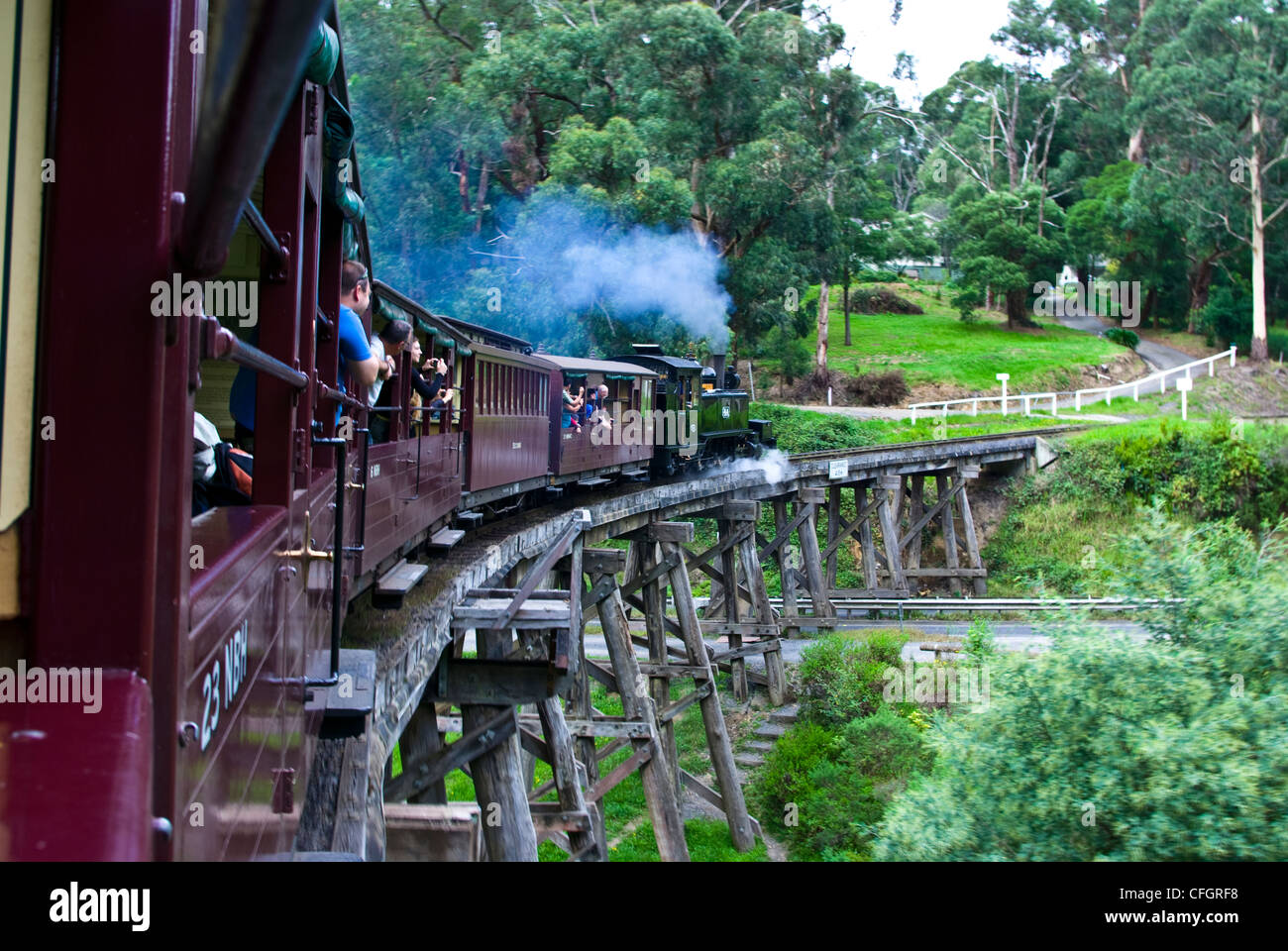 Passagiere auf einem antiken Dampf Zug eine hölzerne Eisenbahnbrücke überquert. Stockfoto
