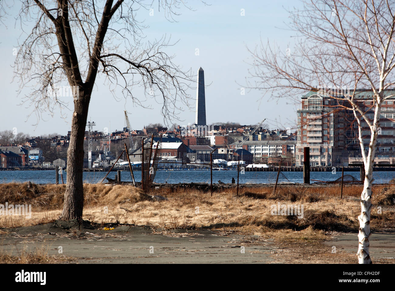 Das Bunker Hill Monument sieht man hinter ein unbebautes Grundstück auf dem Wasser East Boston, Boston, Massachusetts Stockfoto