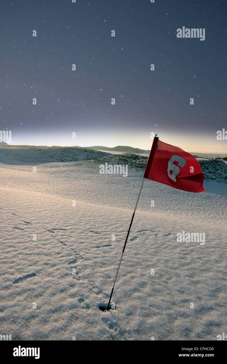 Flagge auf einer Schnee bedeckten Links-Golfplatz in der Nacht in Irland im winter Stockfoto