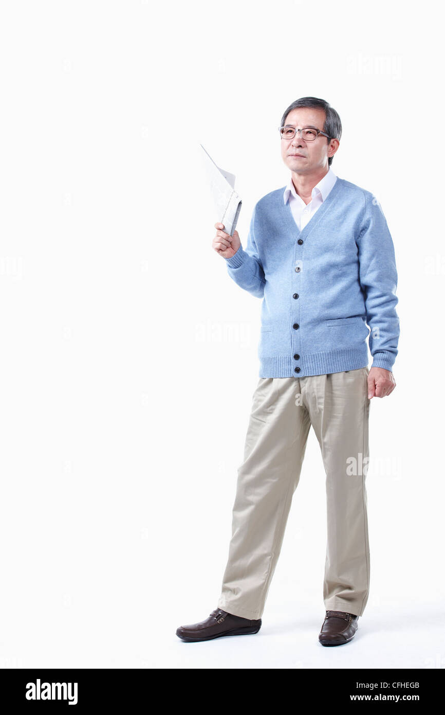 Ein älterer Mann mit einer Zeitung in Gläser Stockfoto