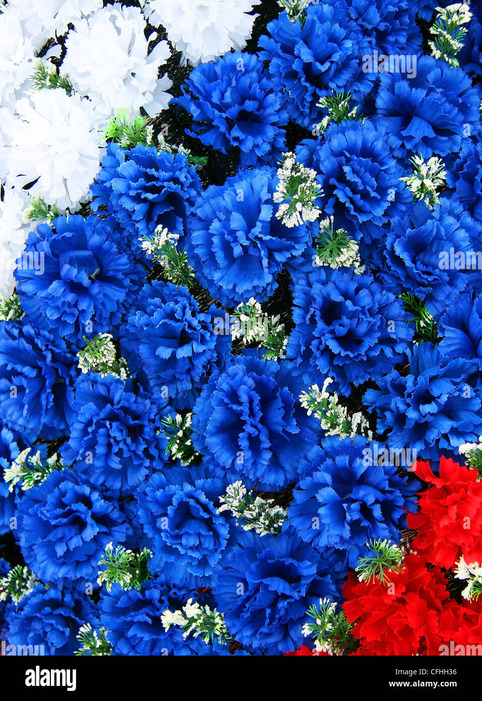 Blüten weiß-blau und rot auf einem Denkmal Kranz Stockfoto