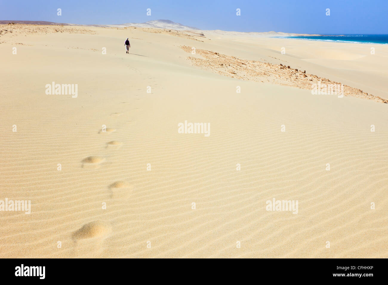Ein entfernter Mensch, der auf Sanddünen spaziert und auf dem weißen Sandstrand von Praia de Chaves, Rabil, Boa Vista, Kapverdische Inseln Fuß gesetzt hat Stockfoto