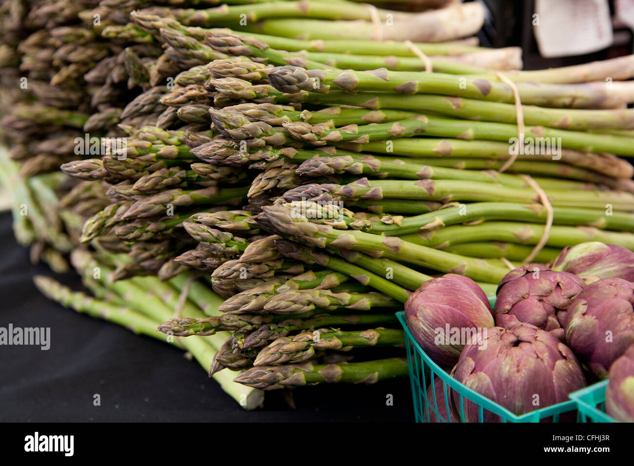 Frisch geerntete Bio Spargel Speere mit Körben lila Artischocken Stockfoto