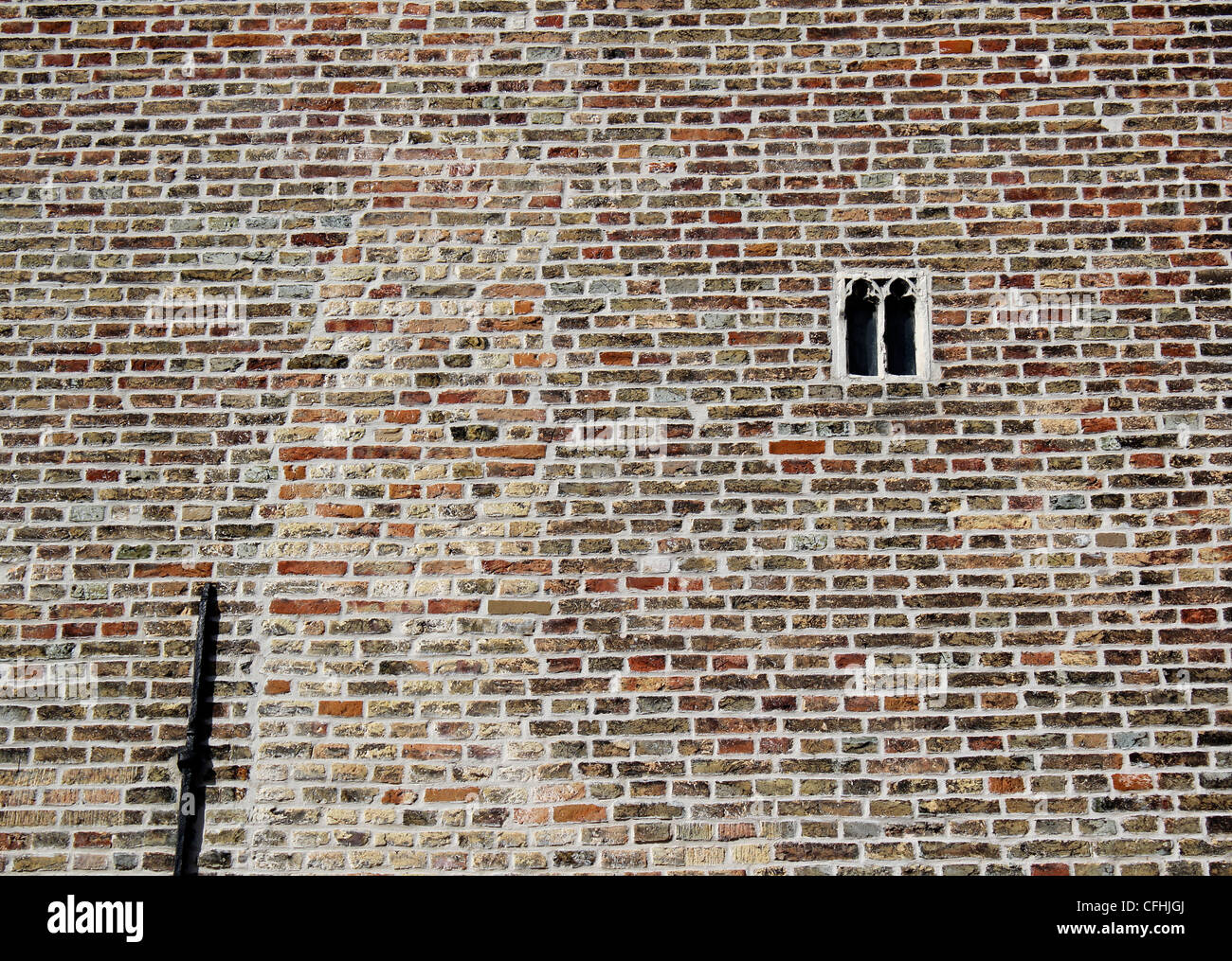 Das kleinste gotische Fenster in Brügge und vielleicht Belgien inmitten einer roten Backsteinmauer mittelalterlichen Stockfoto
