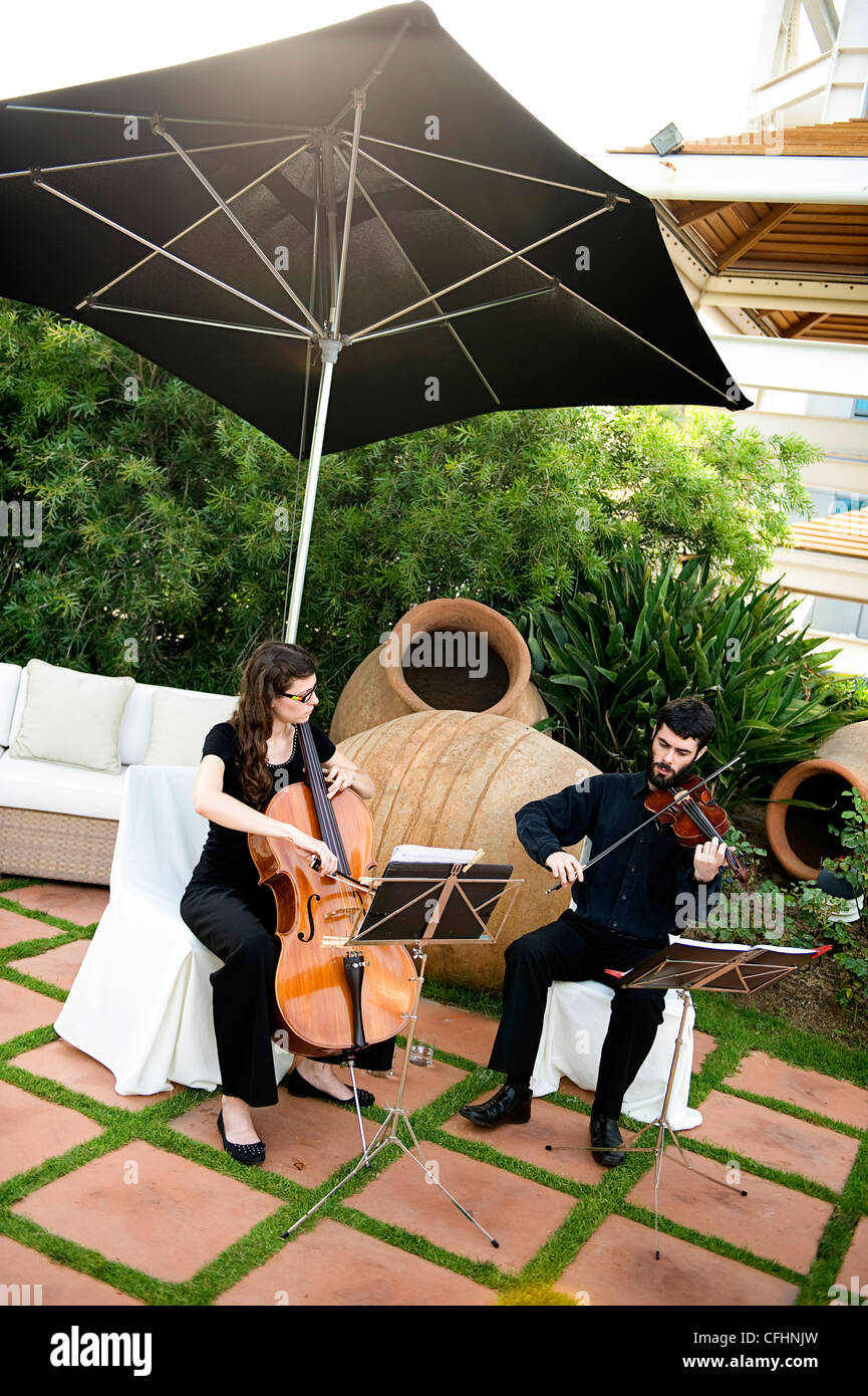 Zwei Musiker spielen Cello und Violine auf einer Terrasse am Hotel Arts Barcelona, Spanien Stockfoto