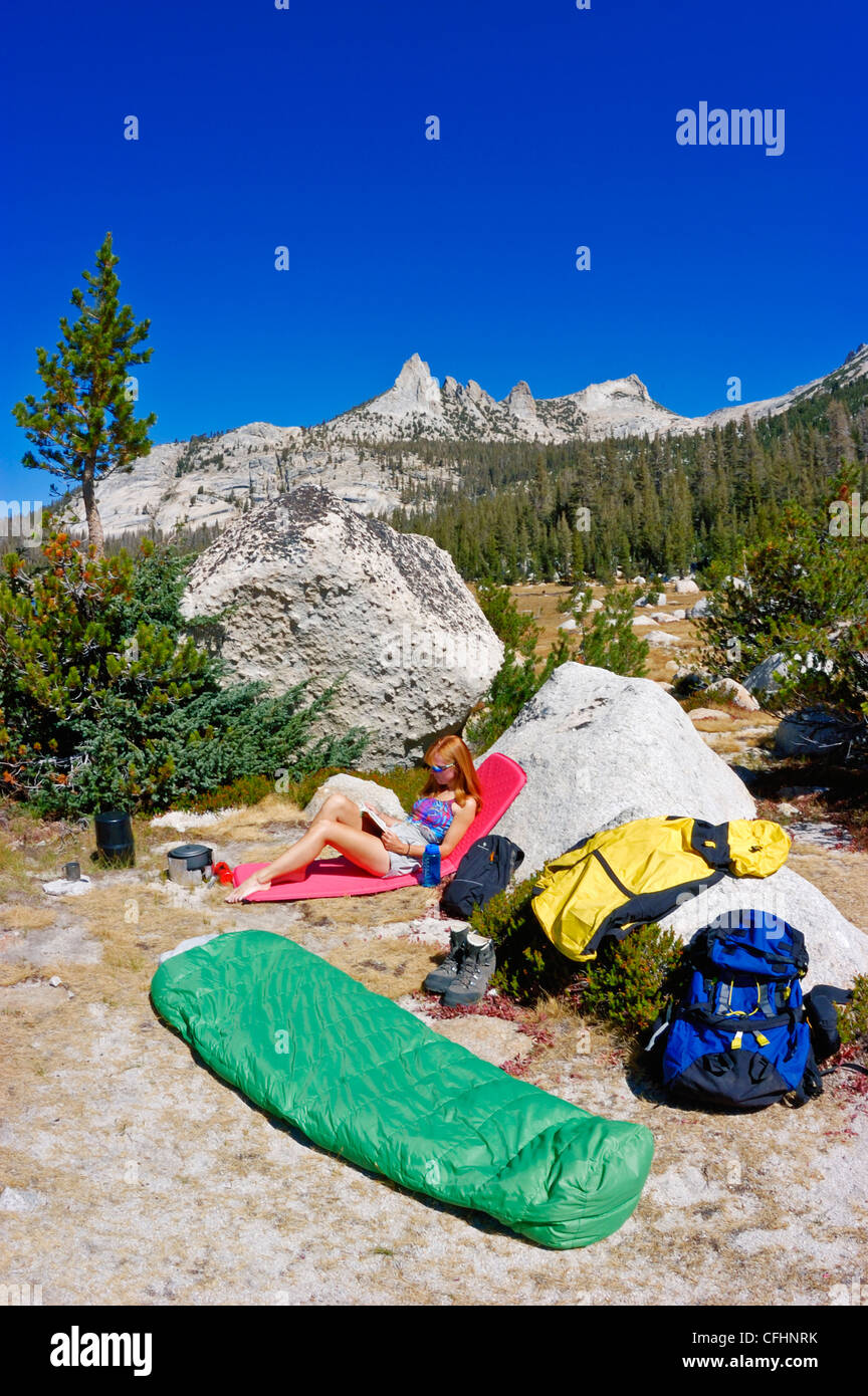 Frau entspannen im Camp unter Echo Gipfeln (backpacking Ausrüstung sichtbar), Yosemite-Nationalpark, Kalifornien Stockfoto