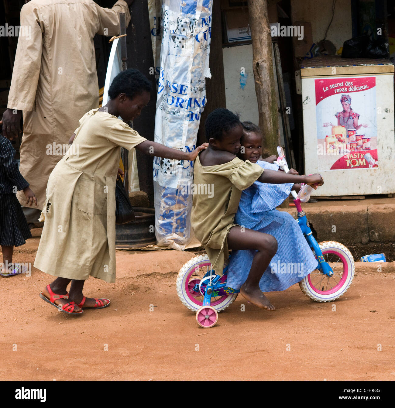 Niedliche togolesische Kinder mit ihrem Fahrrad Spielzeug spielen. Stockfoto