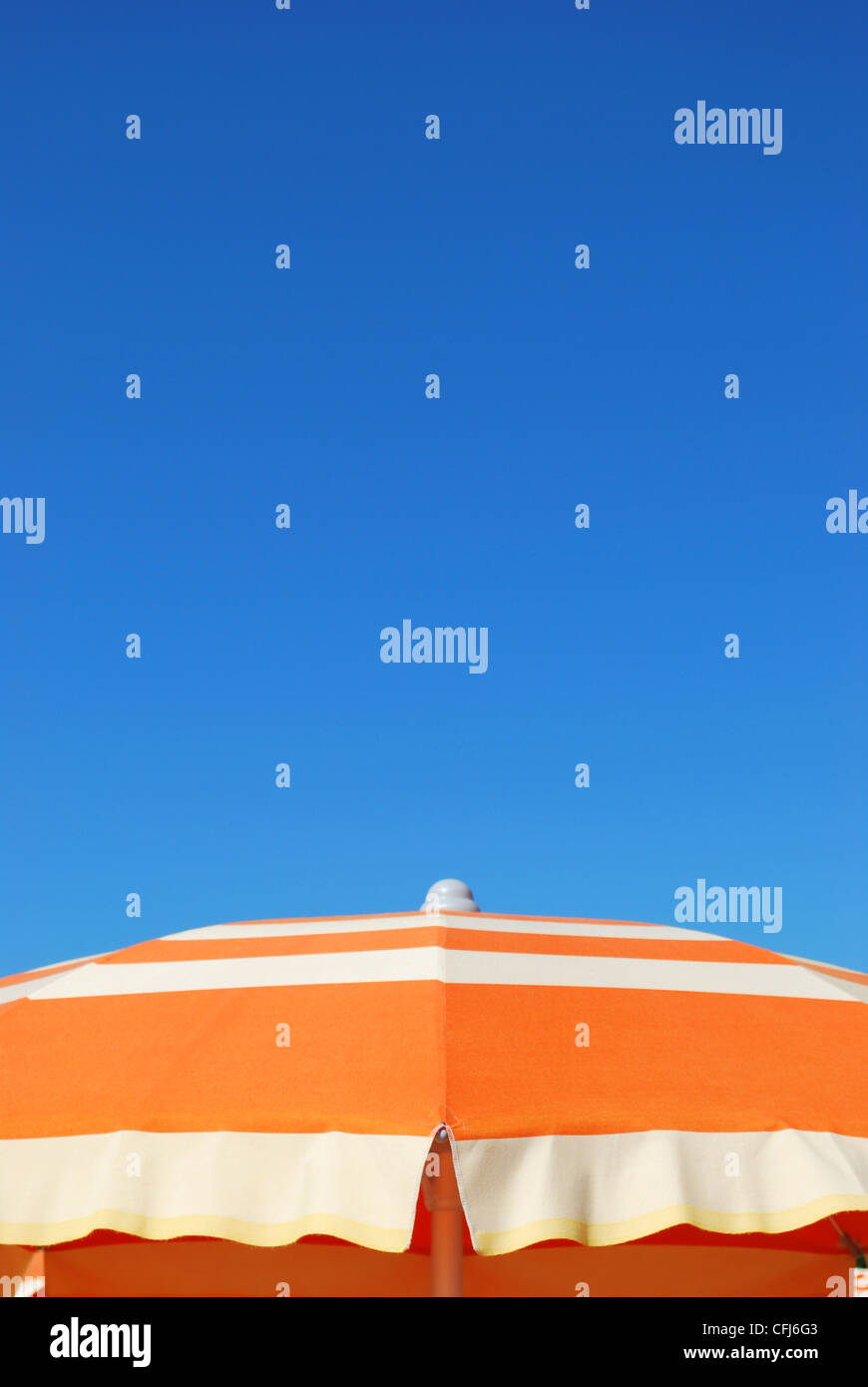 Orange gestreift Sonnenschirm über blauer Himmel, freier Raum für Text, Rimini, Italien Stockfoto