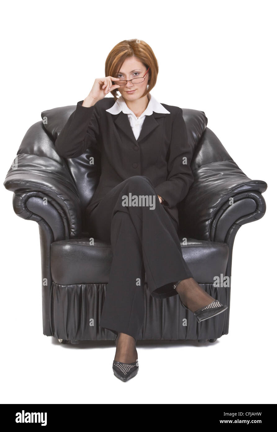 Geschäftsfrau mit Brille in einem Sessel sitzend. Stockfoto